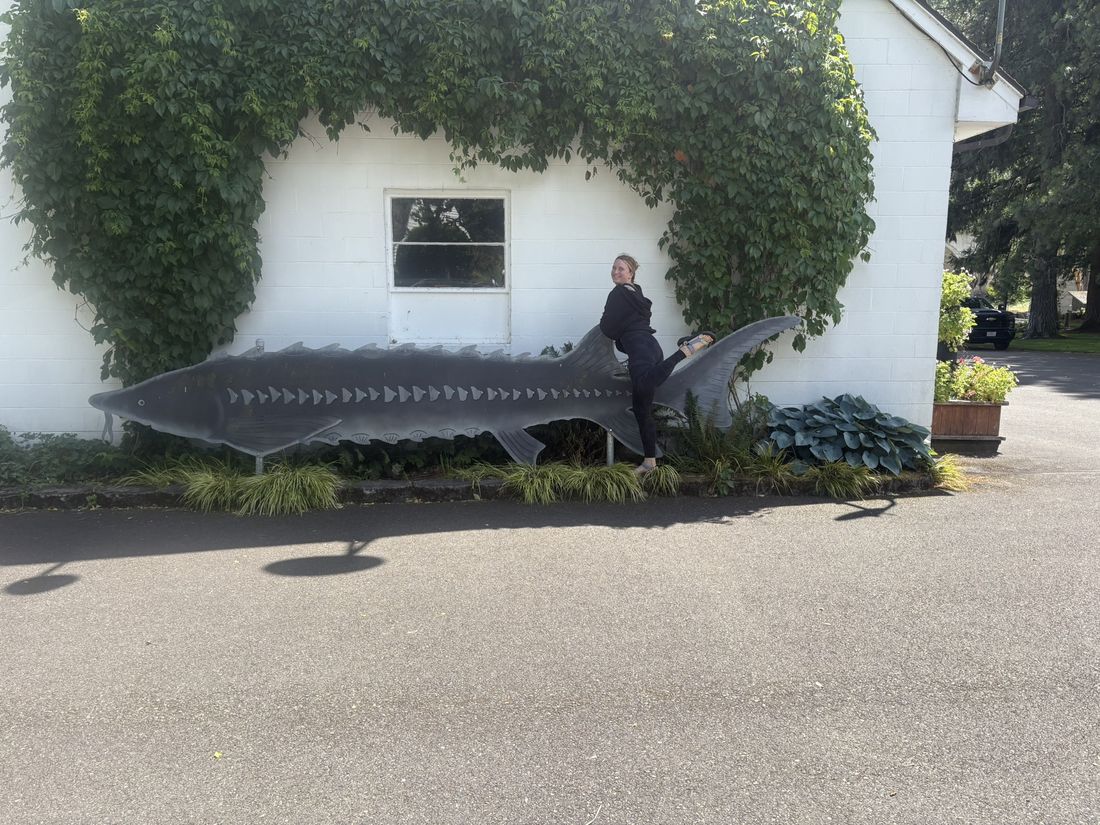 Becky riding a sturgeon sculpture